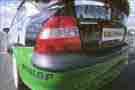 Reflections of the clouds and sky in the body 
panels of a vauxhall vecra race car.